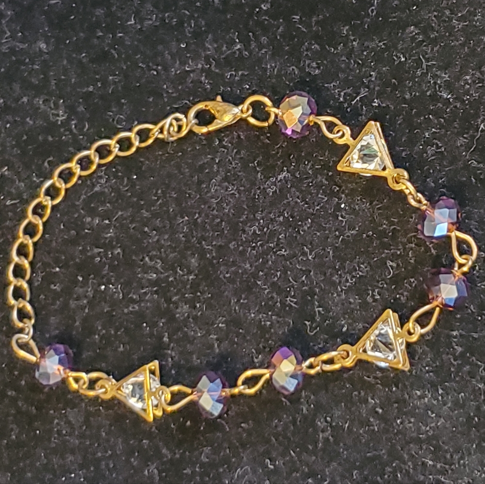 Goldtone adjustable bracelet with purple iridescent beads, caged faux diamonds